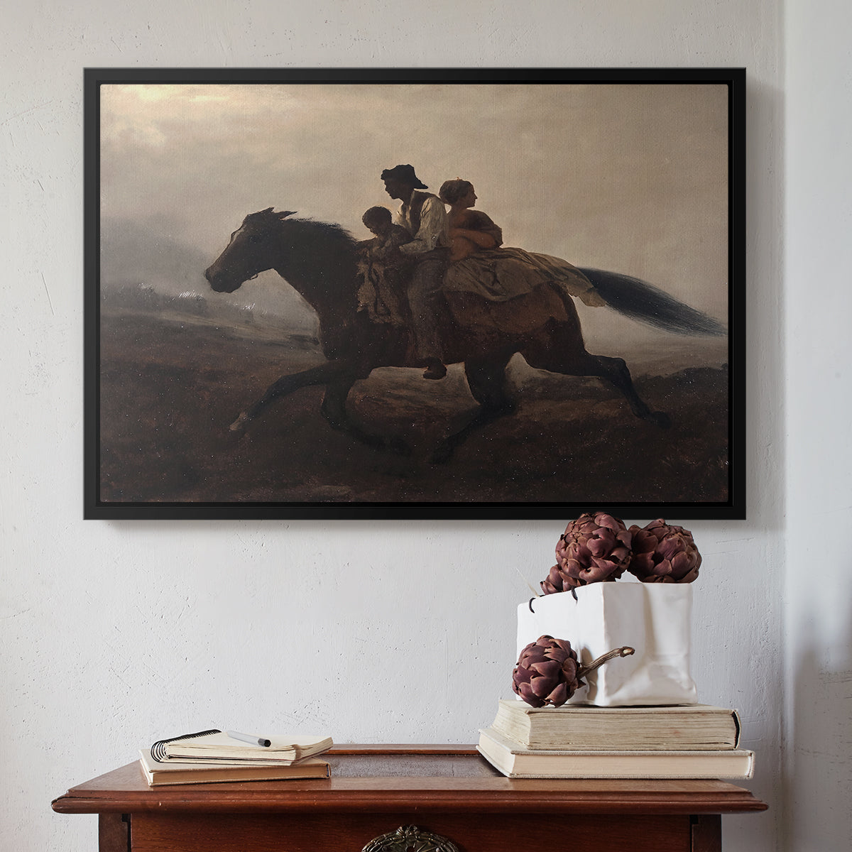 Black floater framed canvas featuring A Ride for Liberty – The Fugitive Slaves, c. 1862 by Eastman Johnson above an entryway table in a minimalist foyer.