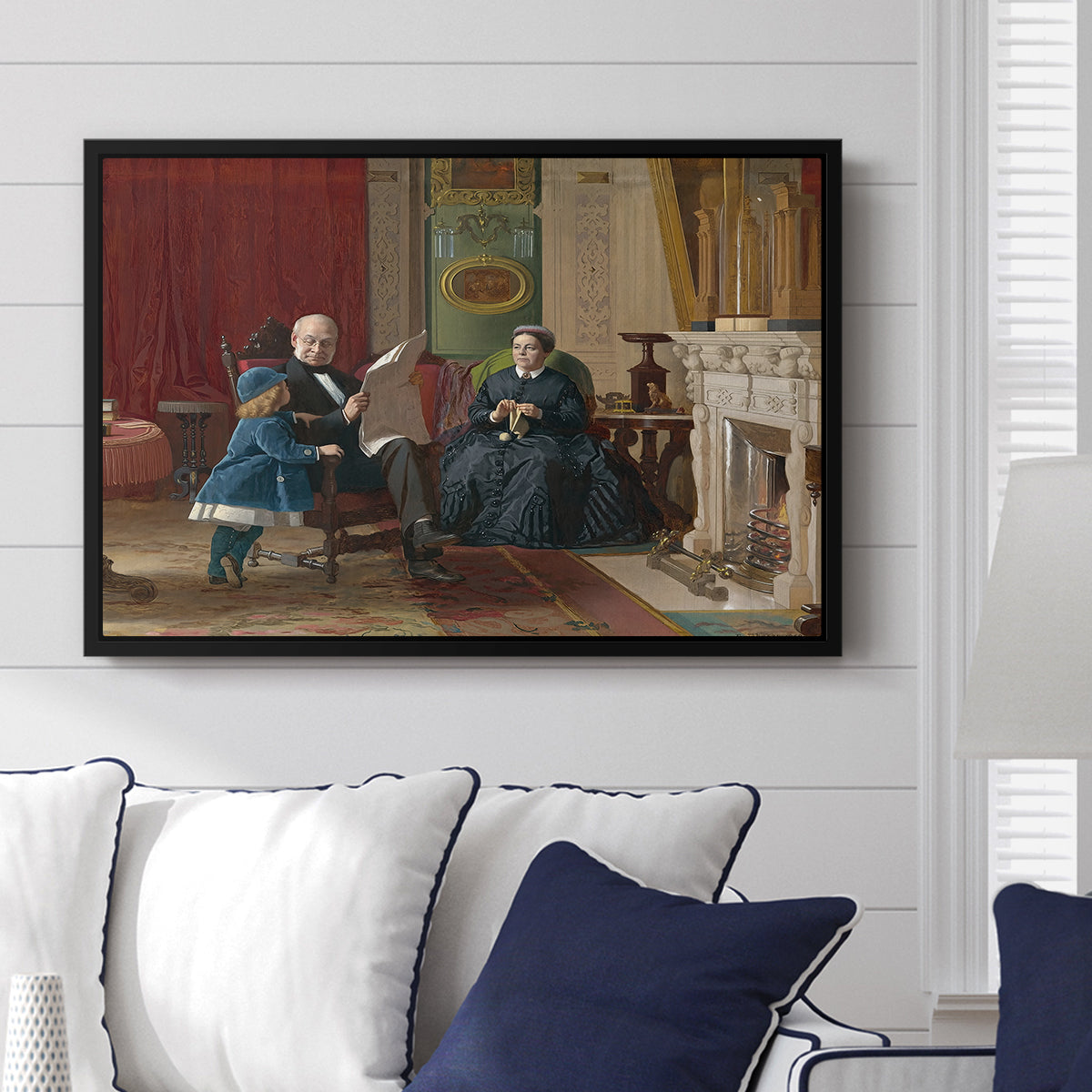 The Brown Family, 1869 by Eastman Johnson displayed above a sofa in a living room in a black floater frame, featuring a domestic portrait of group gathered in modest home setting.