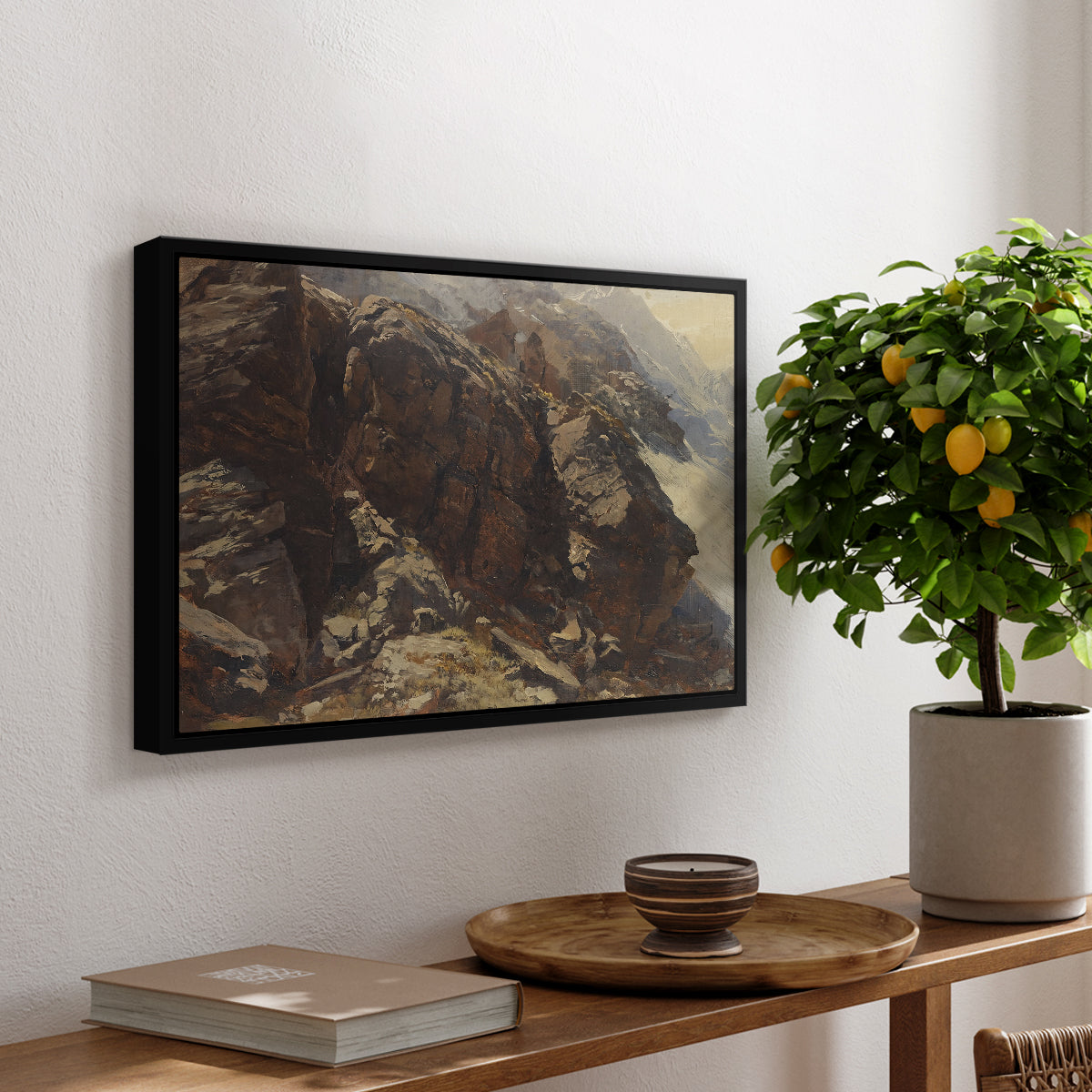 High Mountain Study, c. 1870 by Edward Theodore Compton, presented in a black floater framed canvas featuring a rocky alpine terrain with steep slopes and distant mountain peaks, displayed above a hallway console table.