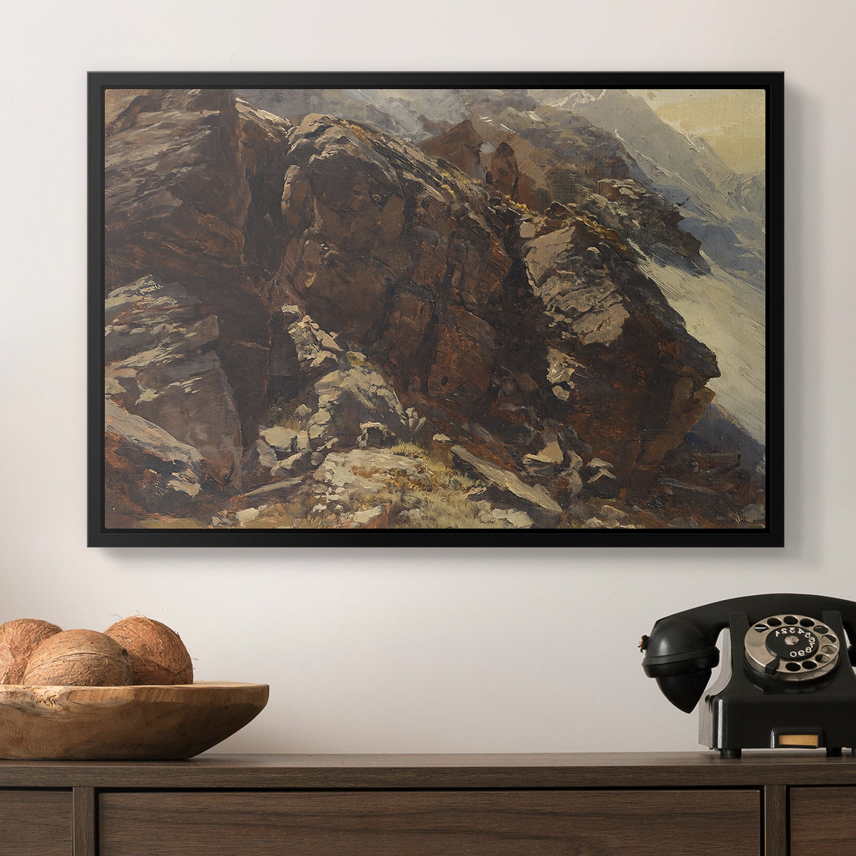 High Mountain Study, c. 1870 by Edward Theodore Compton in a black floater framed canvas displayed above a console table in a hallway, featuring a realistic depiction of mountainous terrain under open sky.