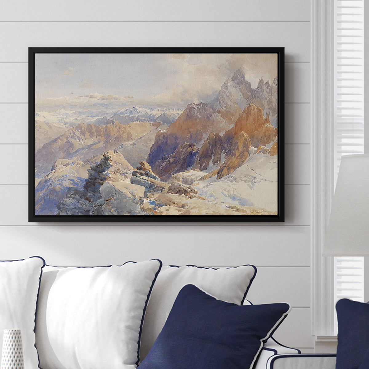 Col du Géant, 1903 by Edward Theodore Compton displayed above a sofa in a living room in a black floater frame, featuring a high mountain landscape featuring dramatic ridges and glacier terrain.