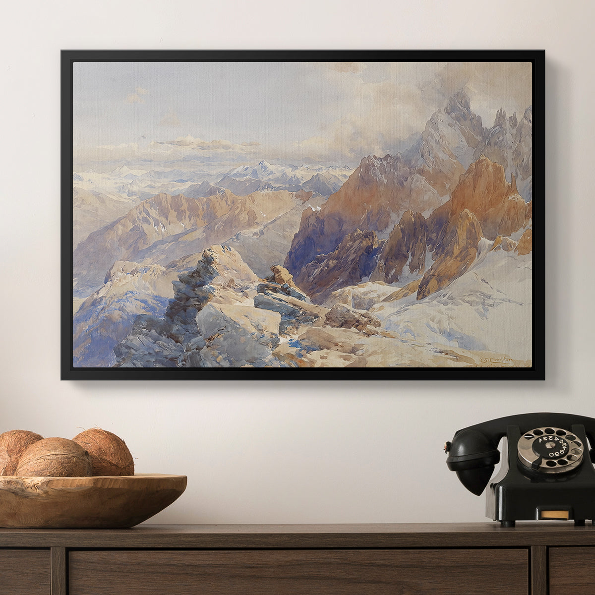 Col du Géant, 1903 by Edward Theodore Compton in a black floater framed canvas displayed above a console table in a hallway, featuring a rugged mountain pass scene with distant peaks.
