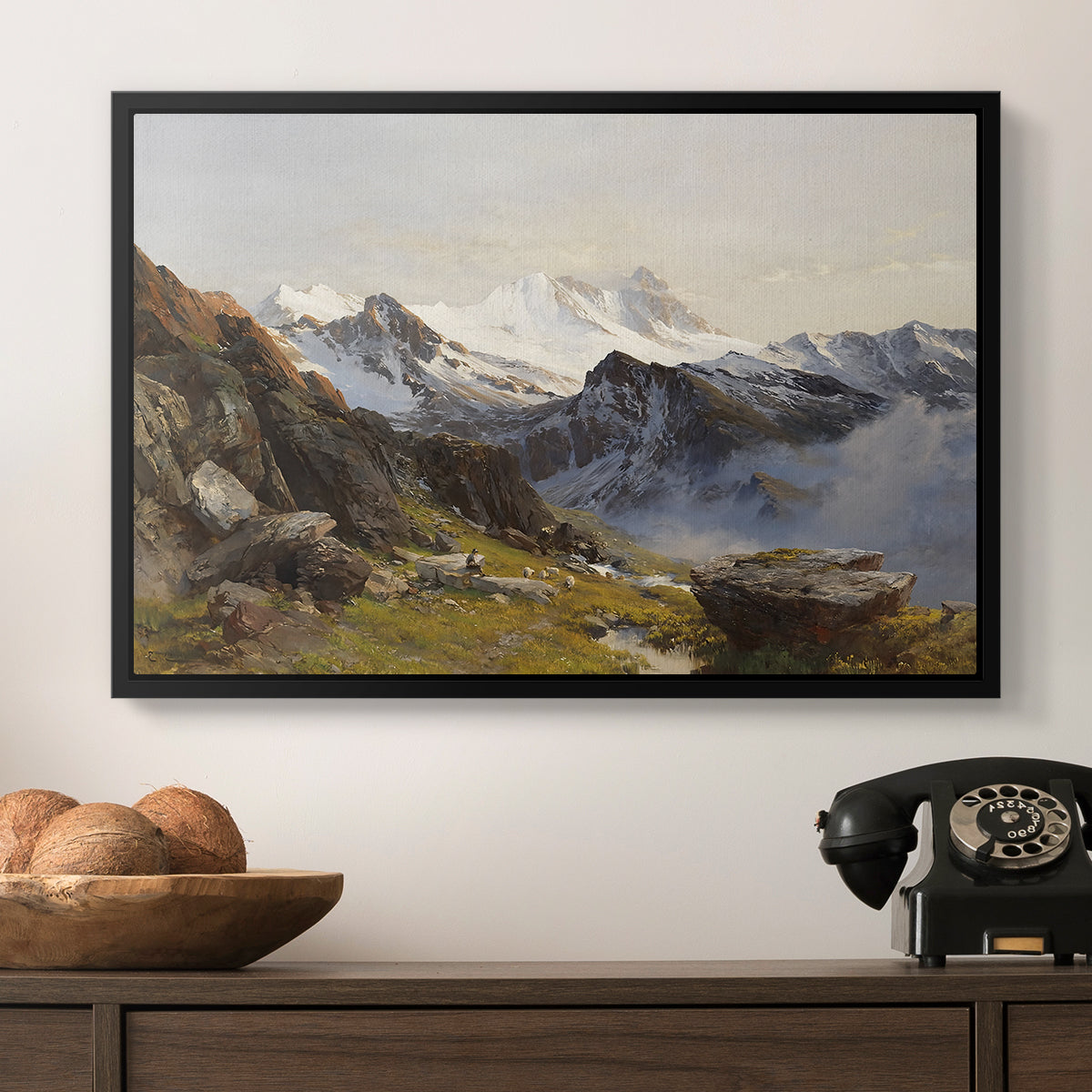 The Großglockner from the Prager Hut, 1890 by Edward Theodore Compton in a black floater framed canvas displayed above a console table in a hallway, featuring a scenic mountain view with dramatic elevation and depth.