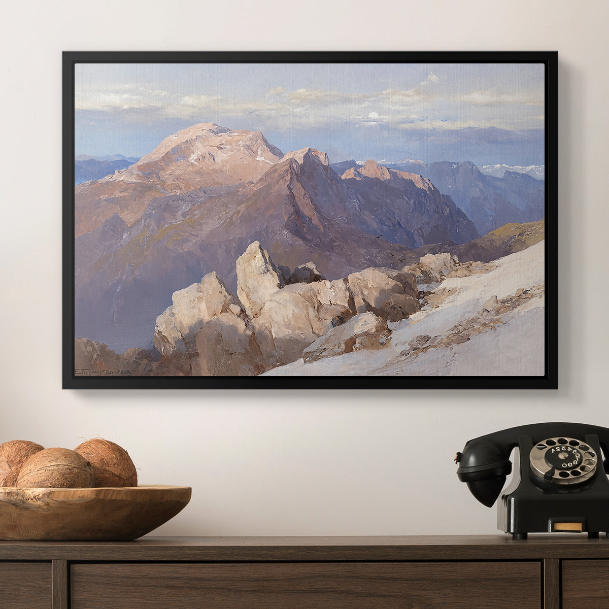 Hoher Göll from Watzmann-Hocheck, 1919 by Edward Theodore Compton in a black floater framed canvas displayed above a console table in a hallway, featuring an expansive mountainous landscape with natural depth.