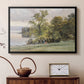 Black floater framed canvas featuring a natural setting with water, trees, and open sky, displayed above a cabinet in a soft-toned living room.