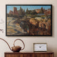 Black floater framed canvas featuring a cityscape with classical ruins and surrounding terrain, displayed above a cabinet in a soft-toned living room.