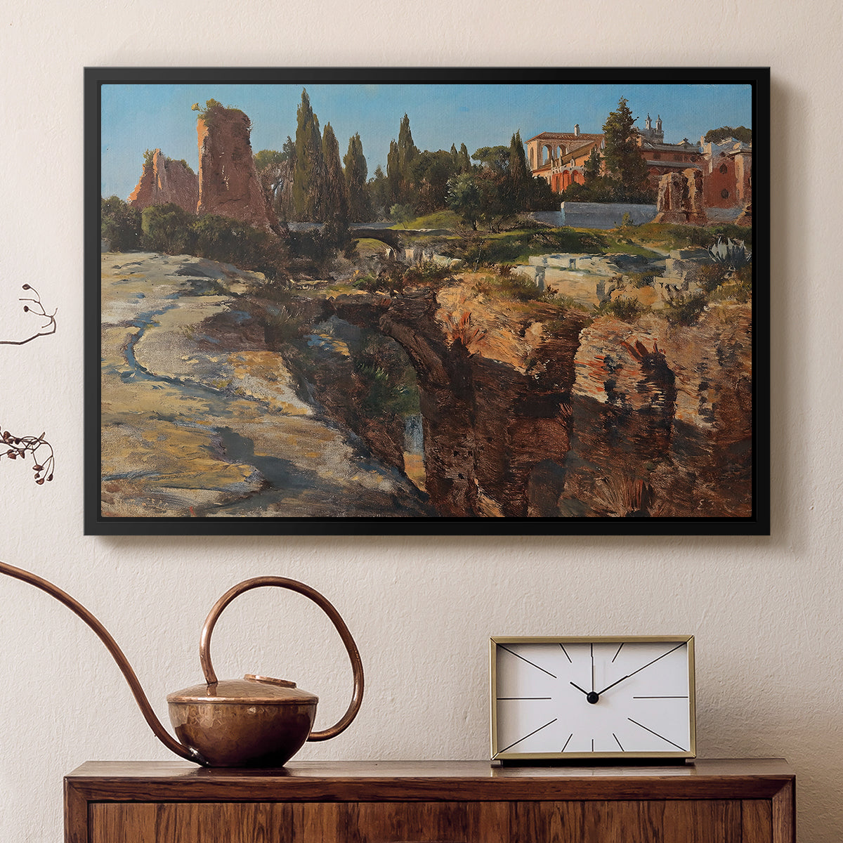 Black floater framed canvas featuring a cityscape with classical ruins and surrounding terrain, displayed above a cabinet in a soft-toned living room.