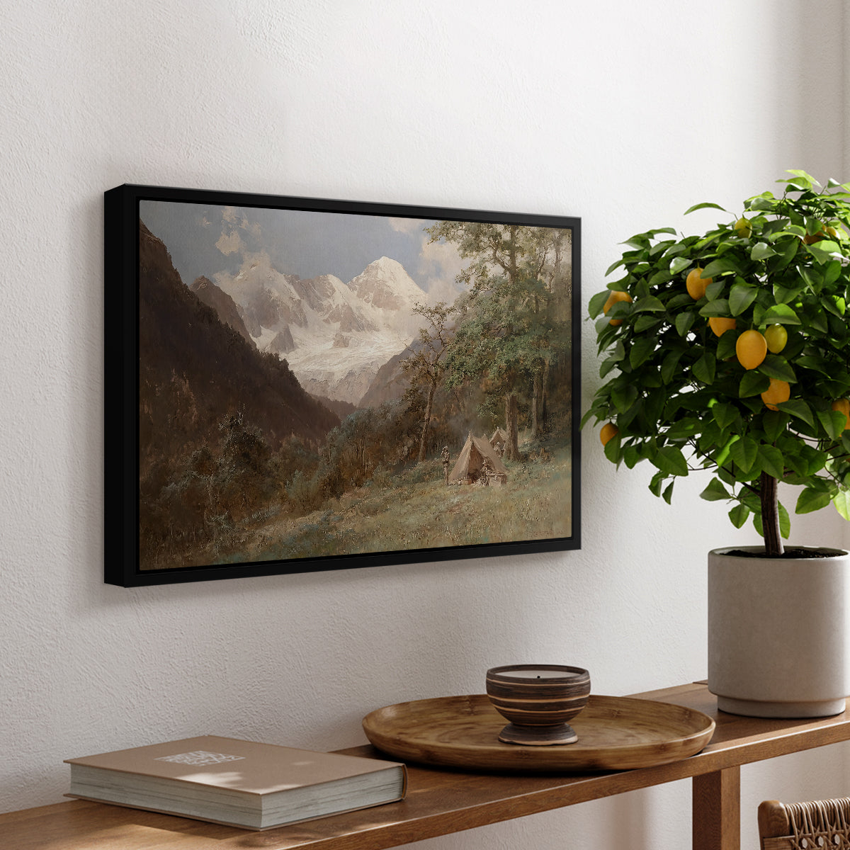 Landscape in the Caucasus, c. 1921 by Edward Theodore Compton, presented in a black floater framed canvas featuring a mountainous landscape with rugged terrain and distant peaks, displayed above a hallway console table.