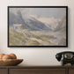 Shepherds (Pasterze), c. 1921 by Edward Theodore Compton in a black floater framed canvas displayed above a console table in a hallway, featuring a natural landscape with human presence among mountains.