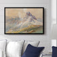 From the Dolomites, 1904 by Edward Theodore Compton displayed above a sofa in a living room in a black floater frame, featuring an alpine scene with jagged rock formations and distant mountains.