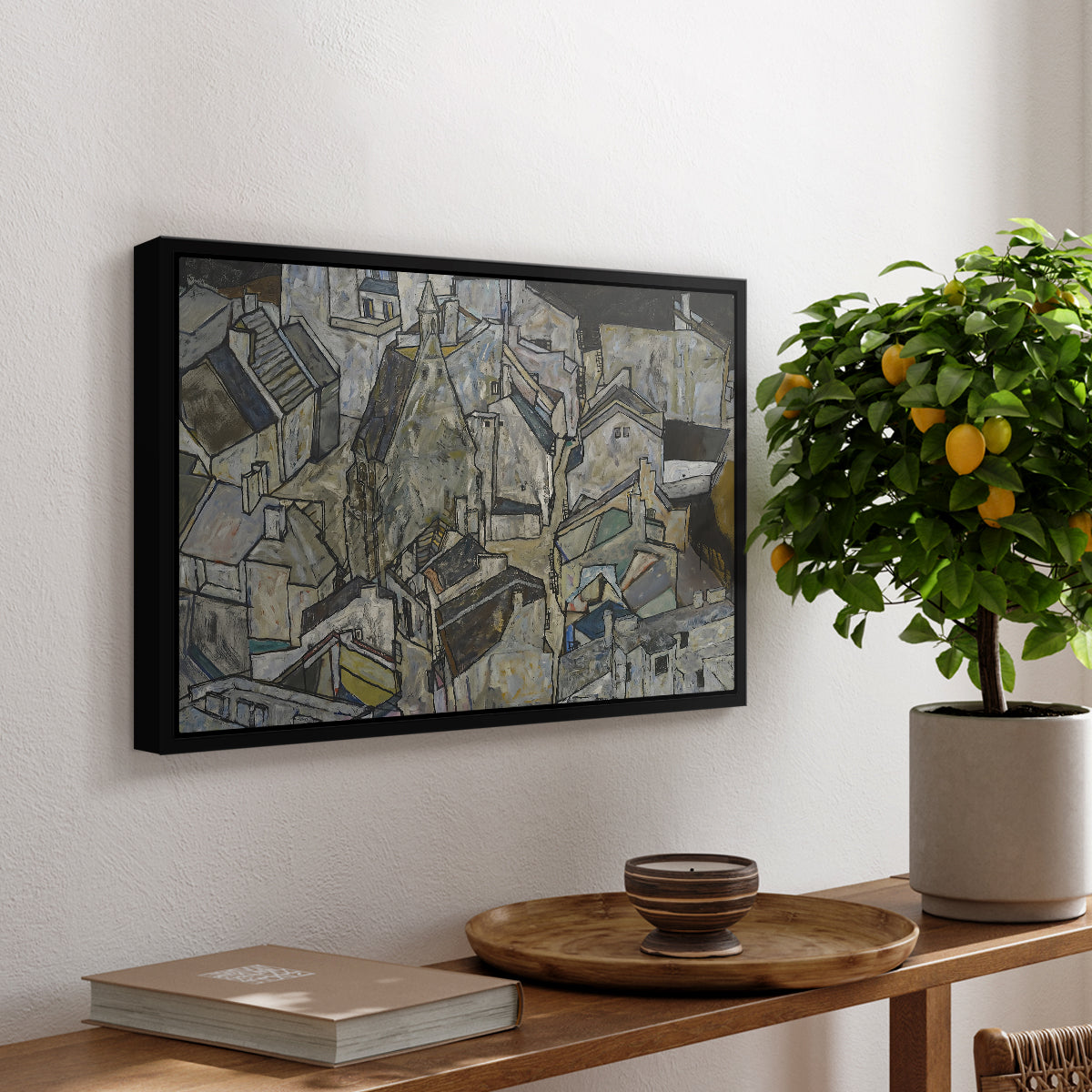 Mödling II, 1918 by Egon Schiele, presented in a black floater framed canvas featuring clustered geometric houses forming dense urban landscape with sharp angles, displayed above a hallway console table.