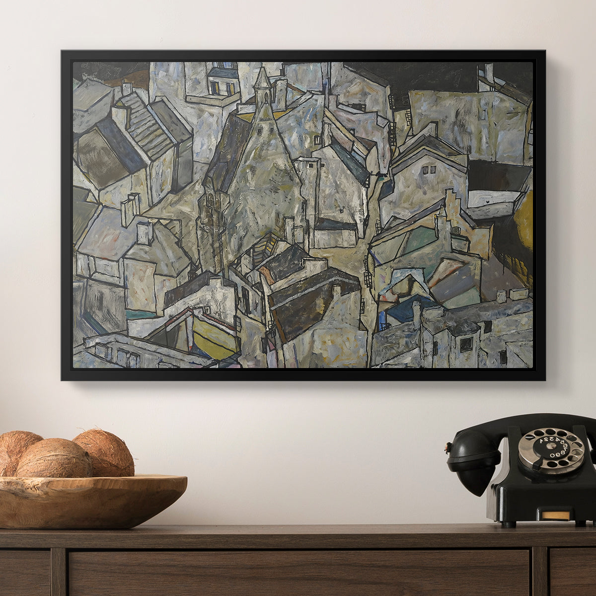 Mödling II, 1918 by Egon Schiele in a black floater framed canvas displayed above a console table in a hallway, featuring a stylized urban composition with geometric structures and muted tones.