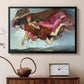 Black floater framed canvas featuring a dreamlike scene with draped figures drifting across dark background, displayed above a cabinet in a soft-toned living room.