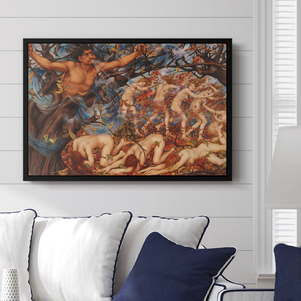Boreas and the Fallen Leaves, c. 1910-1914 by Evelyn De Morgan displayed above a sofa in a living room in a black floater frame, featuring a mythological scene of wind god Boreas moving through autumn leaves.