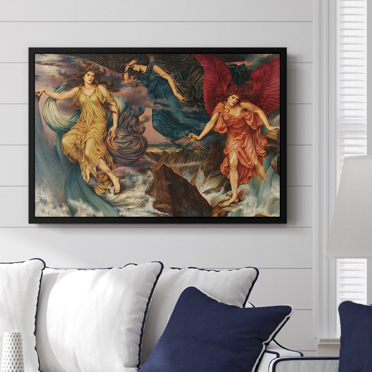 The Storm Spirits, 1900 by Evelyn De Morgan displayed above a sofa in a living room in a black floater frame, featuring a dramatic allegory of spirits moving within turbulent sky.