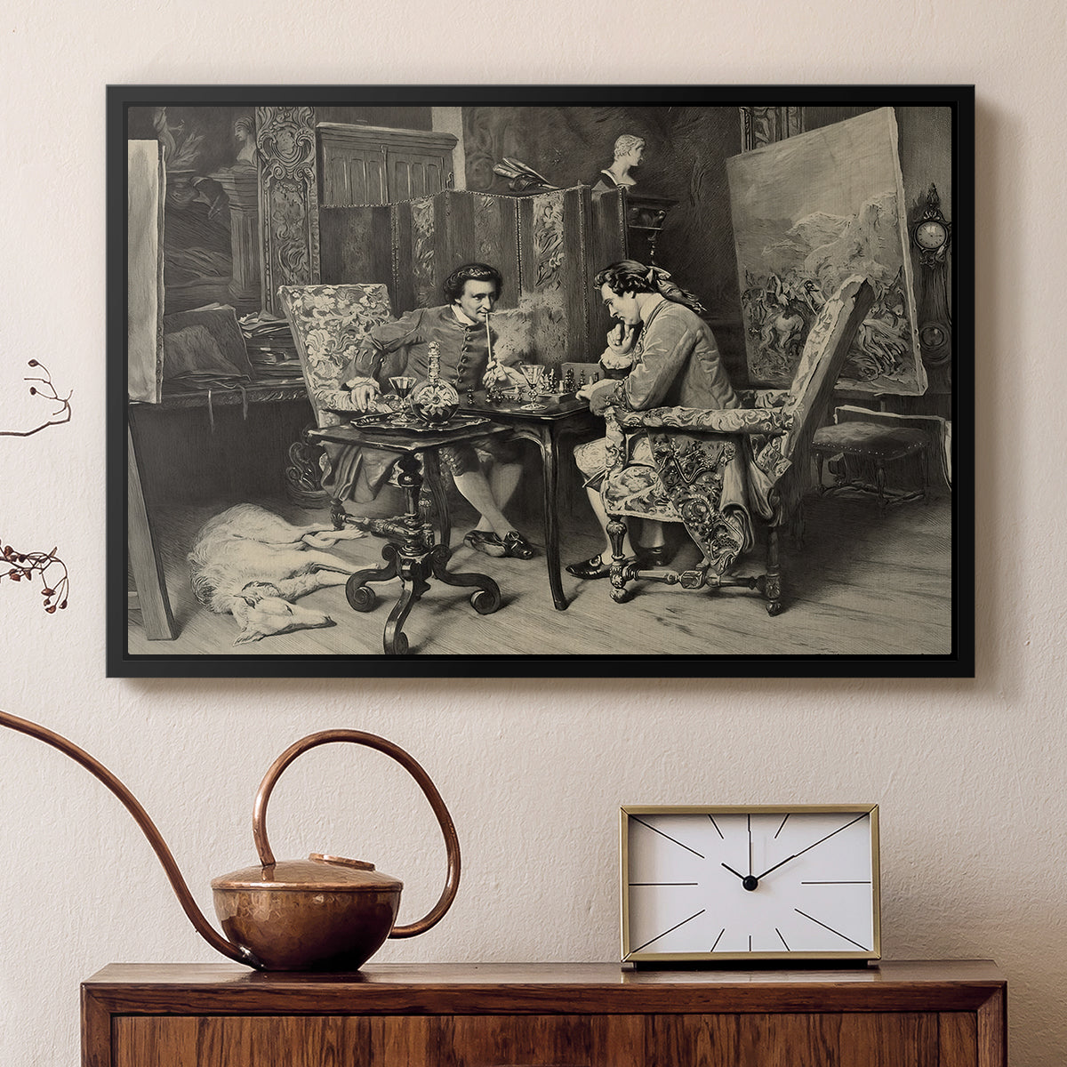 Black floater framed canvas featuring an intimate interior with players focused on board and pieces, displayed above a cabinet in a soft-toned living room.