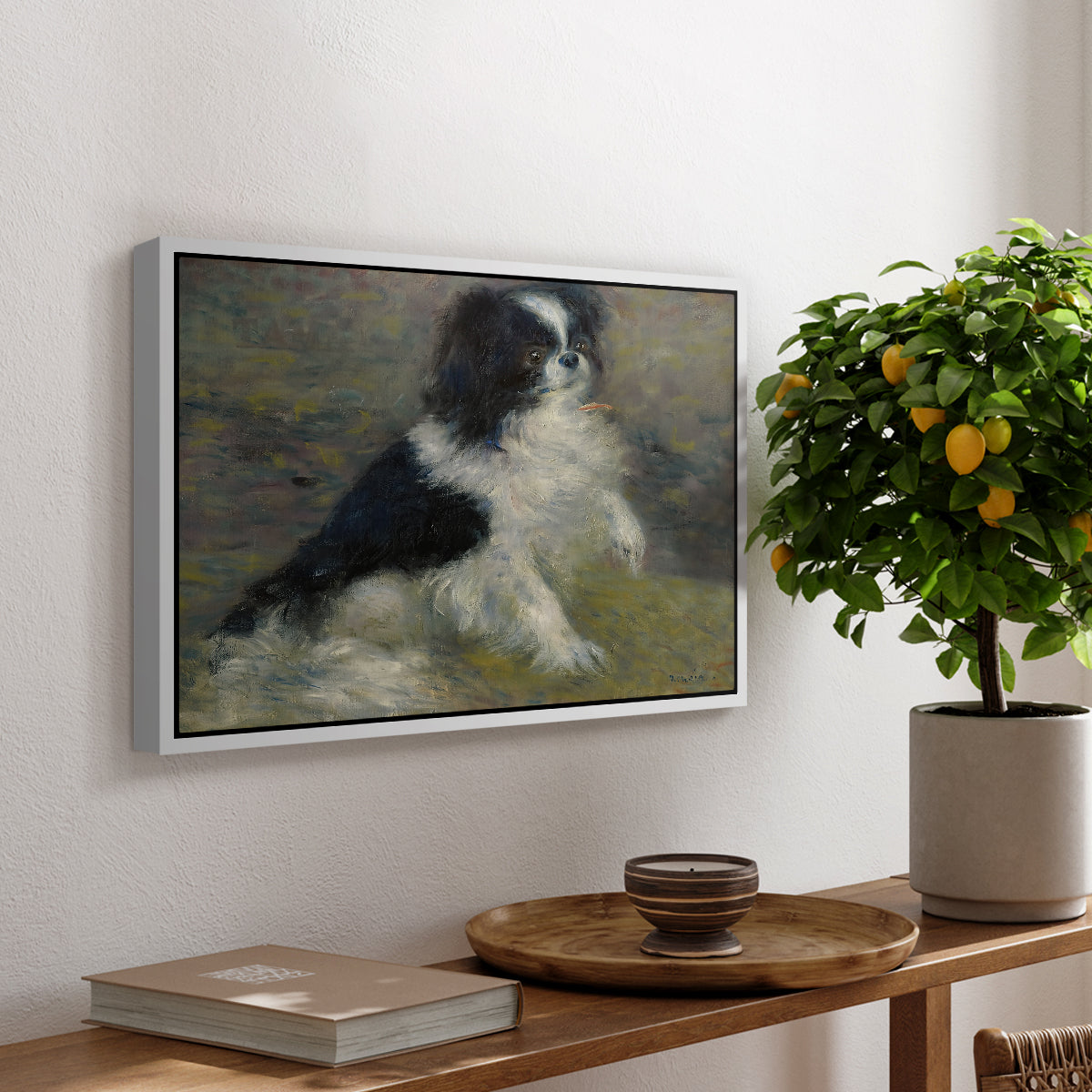 Tama, the Japanese Dog, c. 1876 by Pierre-Auguste Renoir, presented in a white floater framed canvas featuring a small black and white dog standing in shallow water with soft brushstrokes, displayed above a hallway console table.