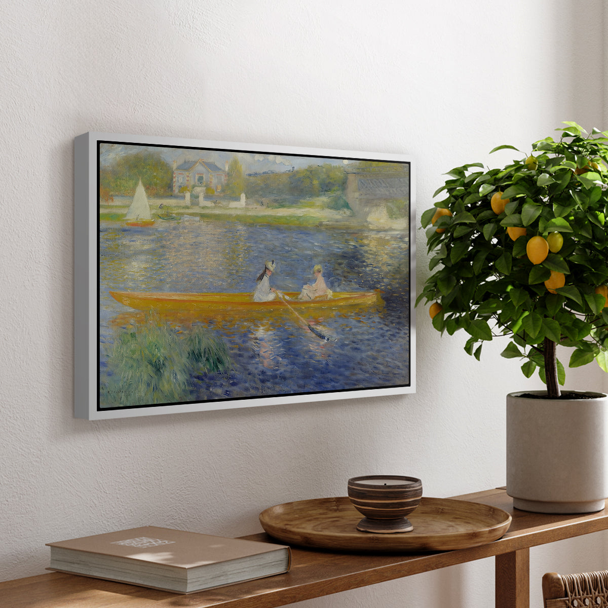 The Skiff (La Yole), 1875 by Pierre-Auguste Renoir, presented in a white floater framed canvas featuring two figures seated in a small boat drifting across calm water, displayed above a hallway console table.