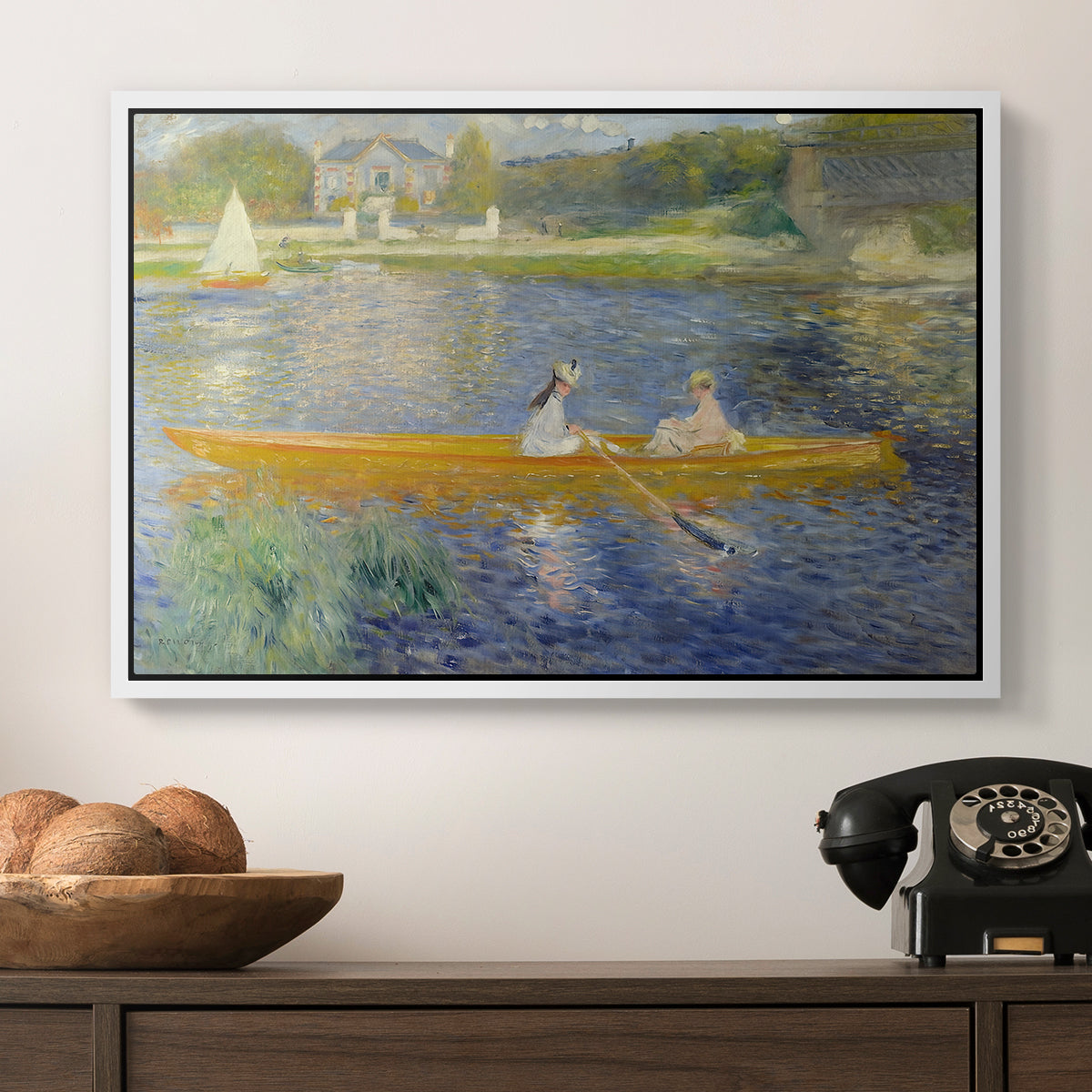 The Skiff (La Yole), 1875 by Pierre-Auguste Renoir in a white floater framed canvas displayed above a console table in a hallway, featuring a leisure scene of figures in a small rowboat on tranquil water.