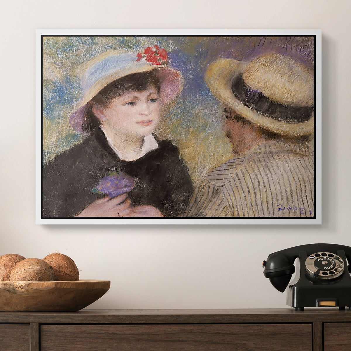 Boating Couple (Aline Charigot and Renoir), c. 1881 by Pierre-Auguste Renoir in a white floater framed canvas displayed above a console table in a hallway, featuring a romantic scene of two figures in casual conversation with soft light.