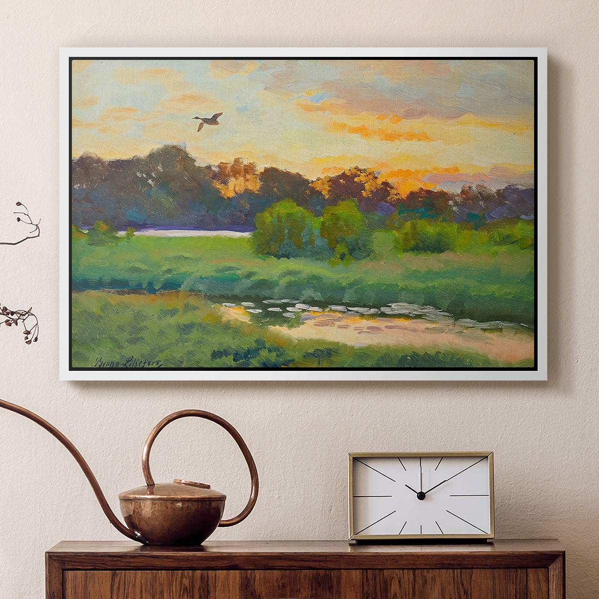 White floater framed canvas featuring a wild duck gliding through a golden sunset sky, displayed above a cabinet in a soft-toned living room.