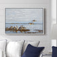 Greylag Geese (Grågäss), 1922 by Bruno Liljefors displayed above a sofa in a living room in a white floater frame, featuring birds standing and resting along shoreline with soft grass and water.