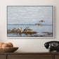 Greylag Geese (Grågäss), 1922 by Bruno Liljefors in a white floater framed canvas displayed above a console table in a hallway, featuring a flock of geese positioned along marshy terrain.