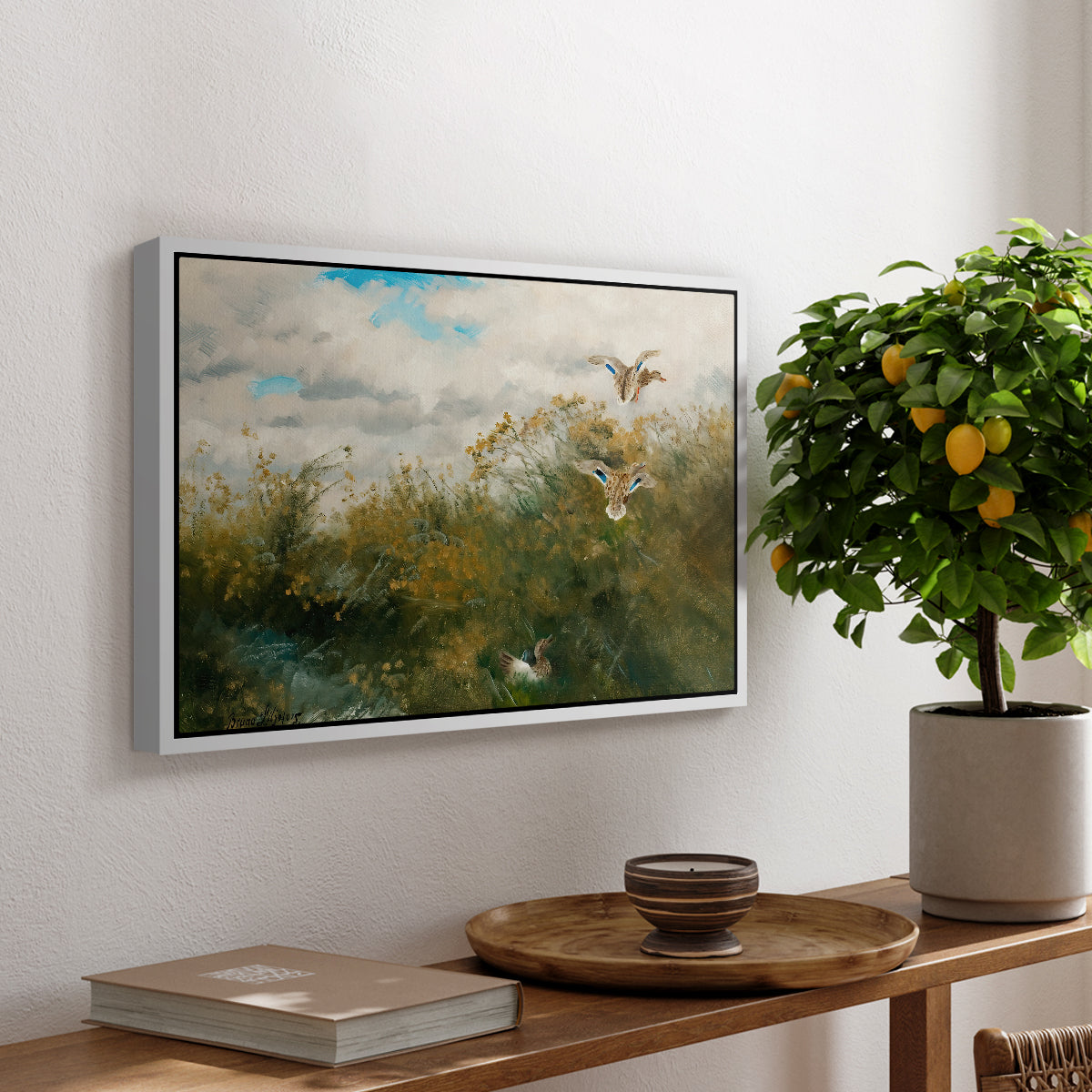 Wild Ducks (Grasänder), 1890 by Bruno Liljefors, presented in a white floater framed canvas featuring ducks moving through grassy wetland near water's edge, displayed above a hallway console table.