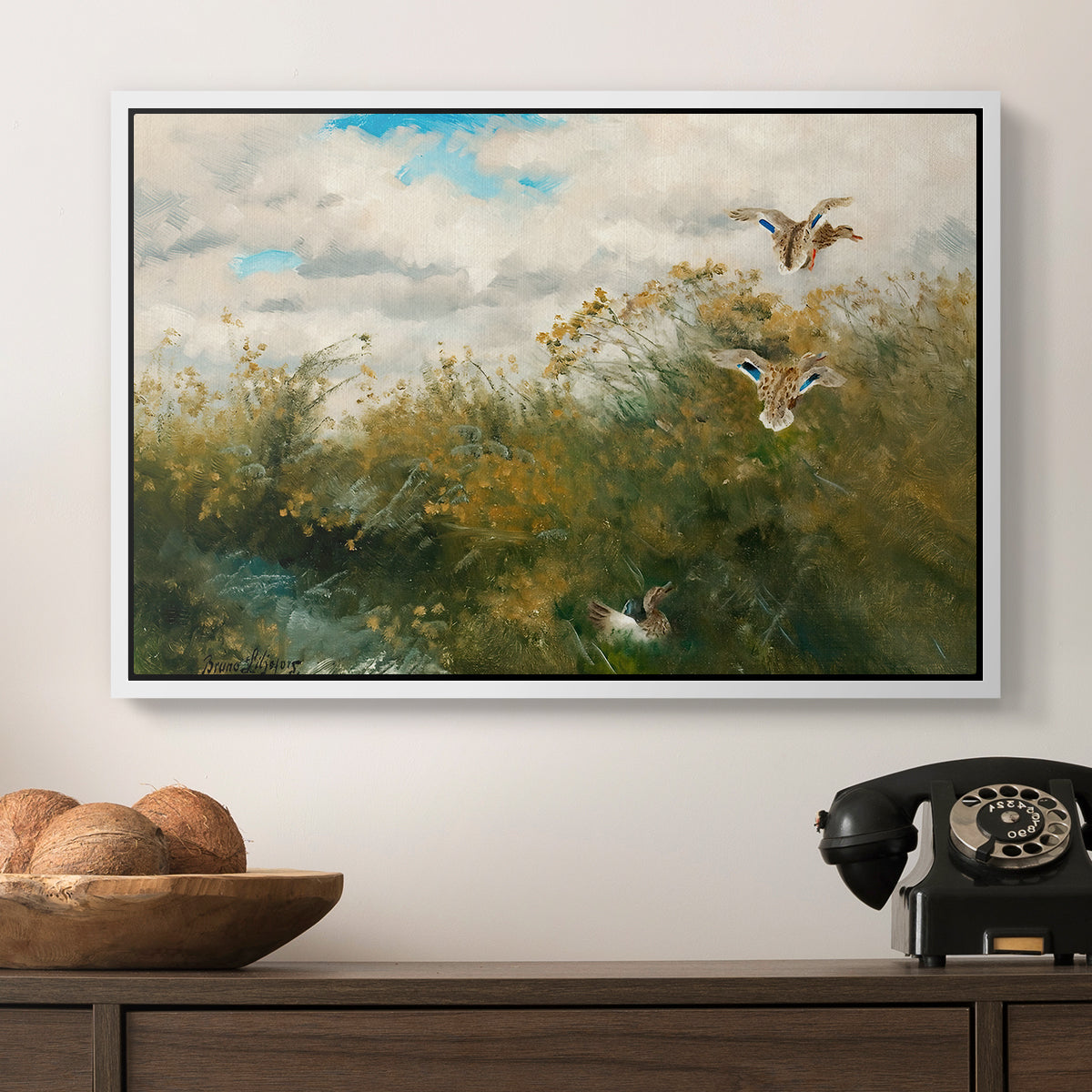 Wild Ducks (Grasänder), 1890 by Bruno Liljefors in a white floater framed canvas displayed above a console table in a hallway, featuring a realistic depiction of ducks in countryside landscape.
