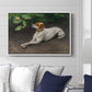 Portrait of a Dog, 1891 by Bruno Liljefors displayed above a sofa in a living room in a white floater frame, featuring a realistic portrait of a resting dog with attentive expression.