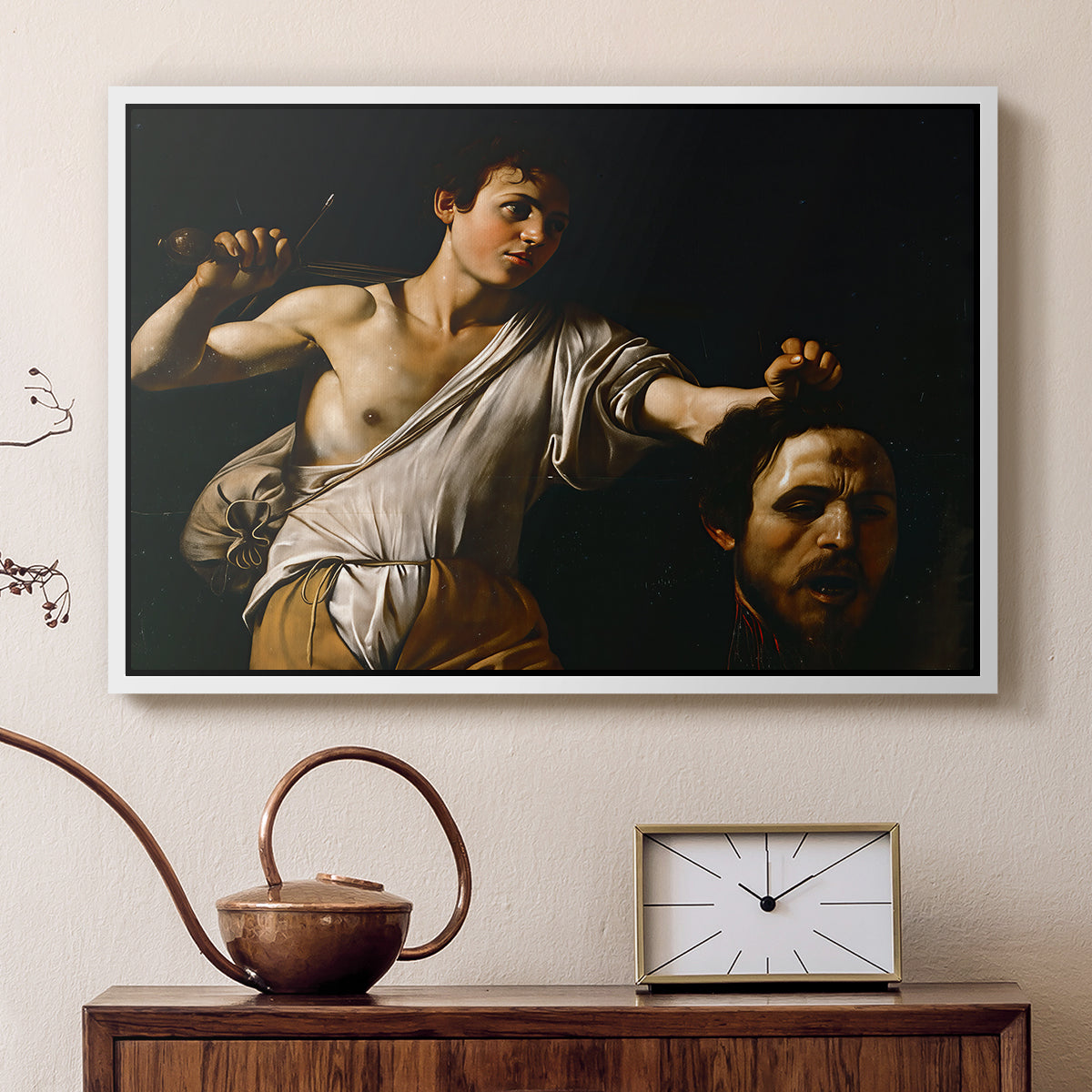 White floater framed canvas featuring a Baroque depiction of youth holding severed head in shadowy setting, displayed above a cabinet in a soft-toned living room.