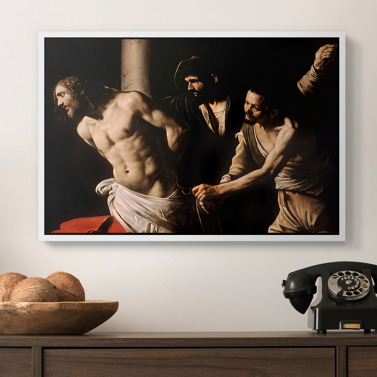 The Flagellation of Christ at the Column (Rouen Version), 1606 by Caravaggio in a white floater framed canvas displayed above a console table in a hallway, featuring an intense Baroque scene of suffering with strong light and shadow.