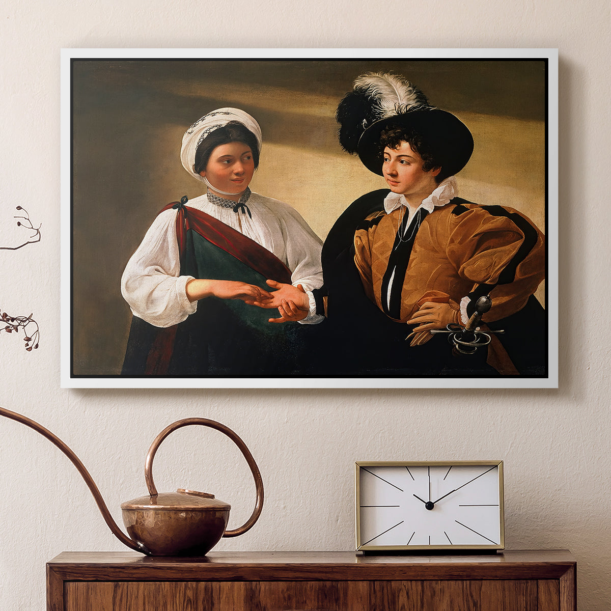 White floater framed canvas featuring an intimate scene of palm reading with subtle act of theft, displayed above a cabinet in a soft-toned living room.