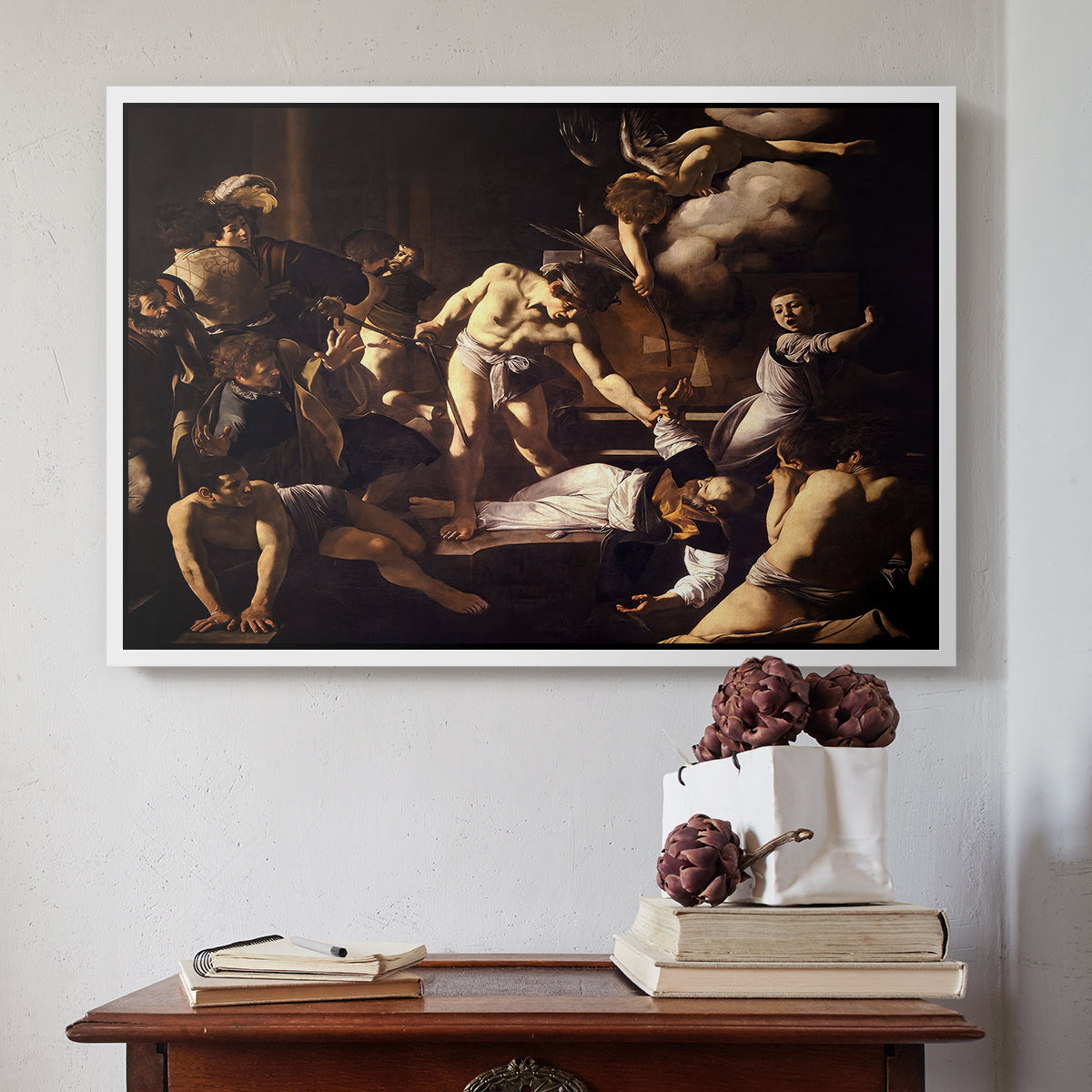 White floater framed canvas featuring The Martyrdom of Saint Matthew, 1599-1600 by Caravaggio above an entryway table in a minimalist foyer.