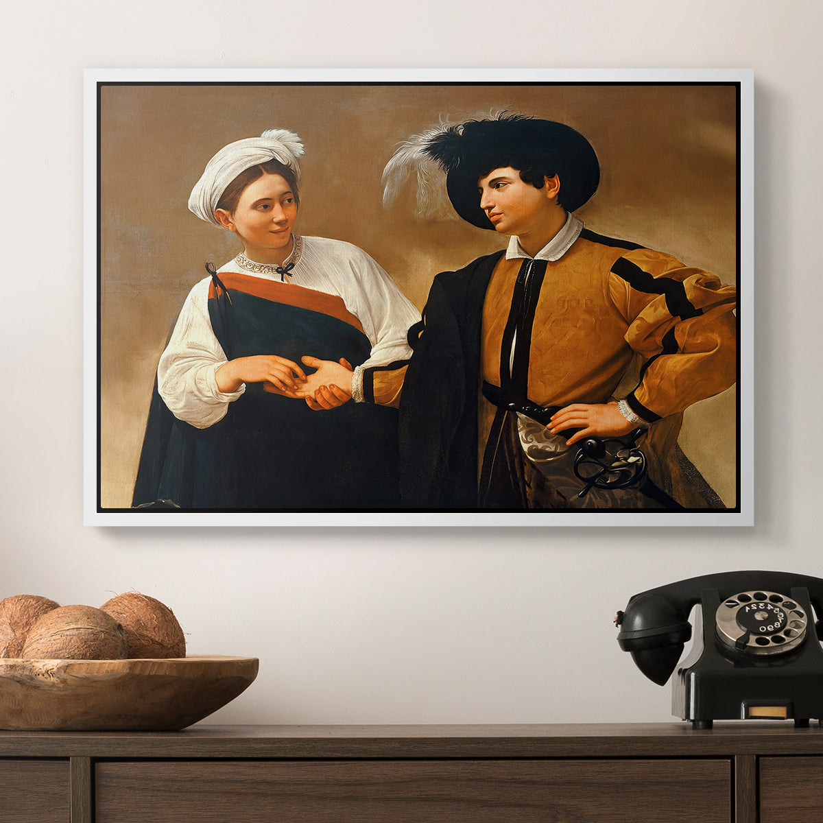 The Fortune Teller (Capitoline Version), c. 1599 by Caravaggio in a white floater framed canvas displayed above a console table in a hallway, featuring a genre scene of fortune telling with subtle theft.
