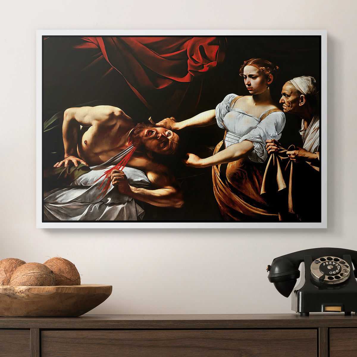 Judith Beheading Holofernes, c. 1599 by Caravaggio in a white floater framed canvas displayed above a console table in a hallway, featuring a violent religious narrative with strong contrast of light and shadow.