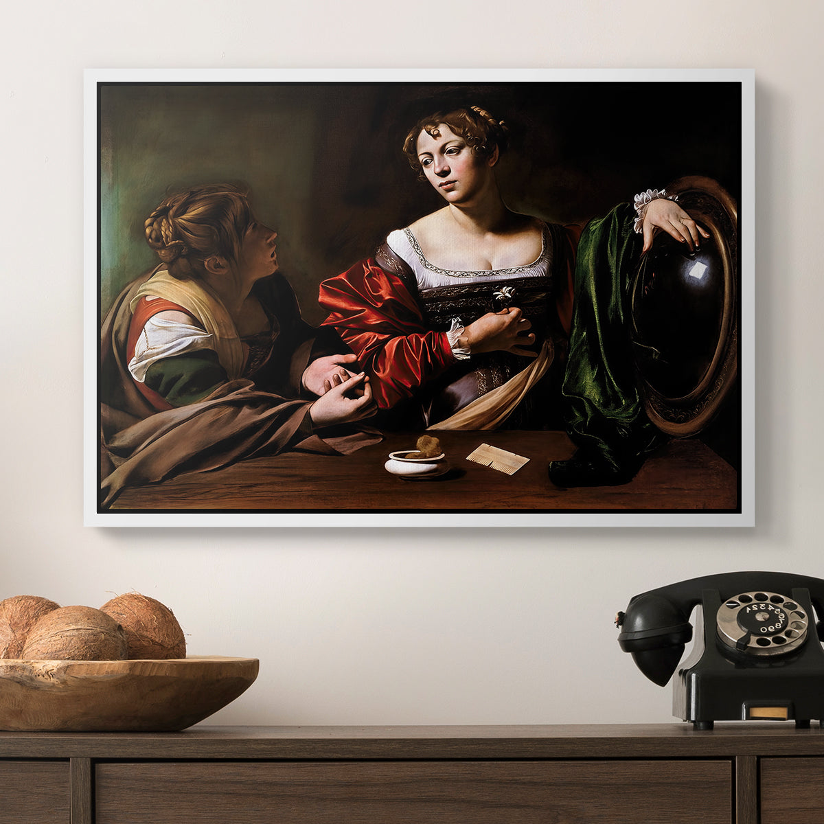 Martha and Mary Magdalene, c. 1598 by Caravaggio in a white floater framed canvas displayed above a console table in a hallway, featuring a religious interior scene with figures engaged in thoughtful dialogue.