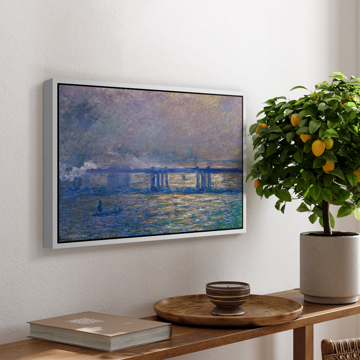 Charing Cross Bridge, 1903 by Claude Monet, presented in a white floater framed canvas featuring an impressionist view of bridge stretching across river with soft light and haze, displayed above a hallway console table.