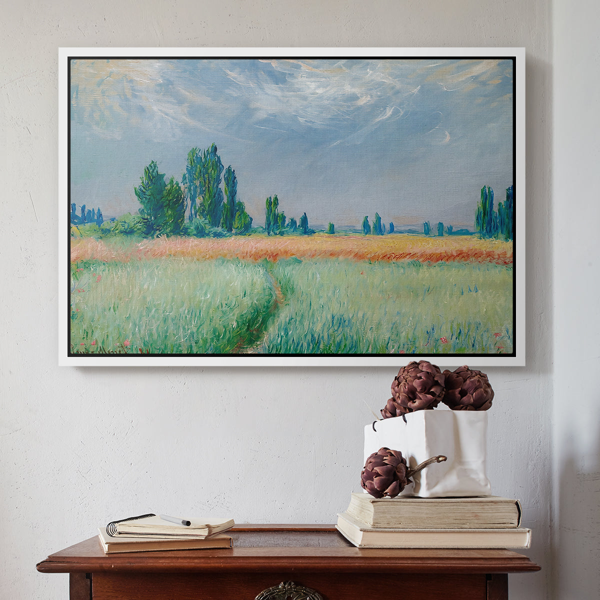 White floater framed canvas featuring The Wheat Field (Champ de Blé), 1881 by Claude Monet above an entryway table in a minimalist foyer.