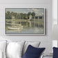 The Bridge at Argenteuil, 1874 by Claude Monet displayed above a sofa in a living room in a white floater frame, featuring an impressionist river scene with boats passing beneath bridge.