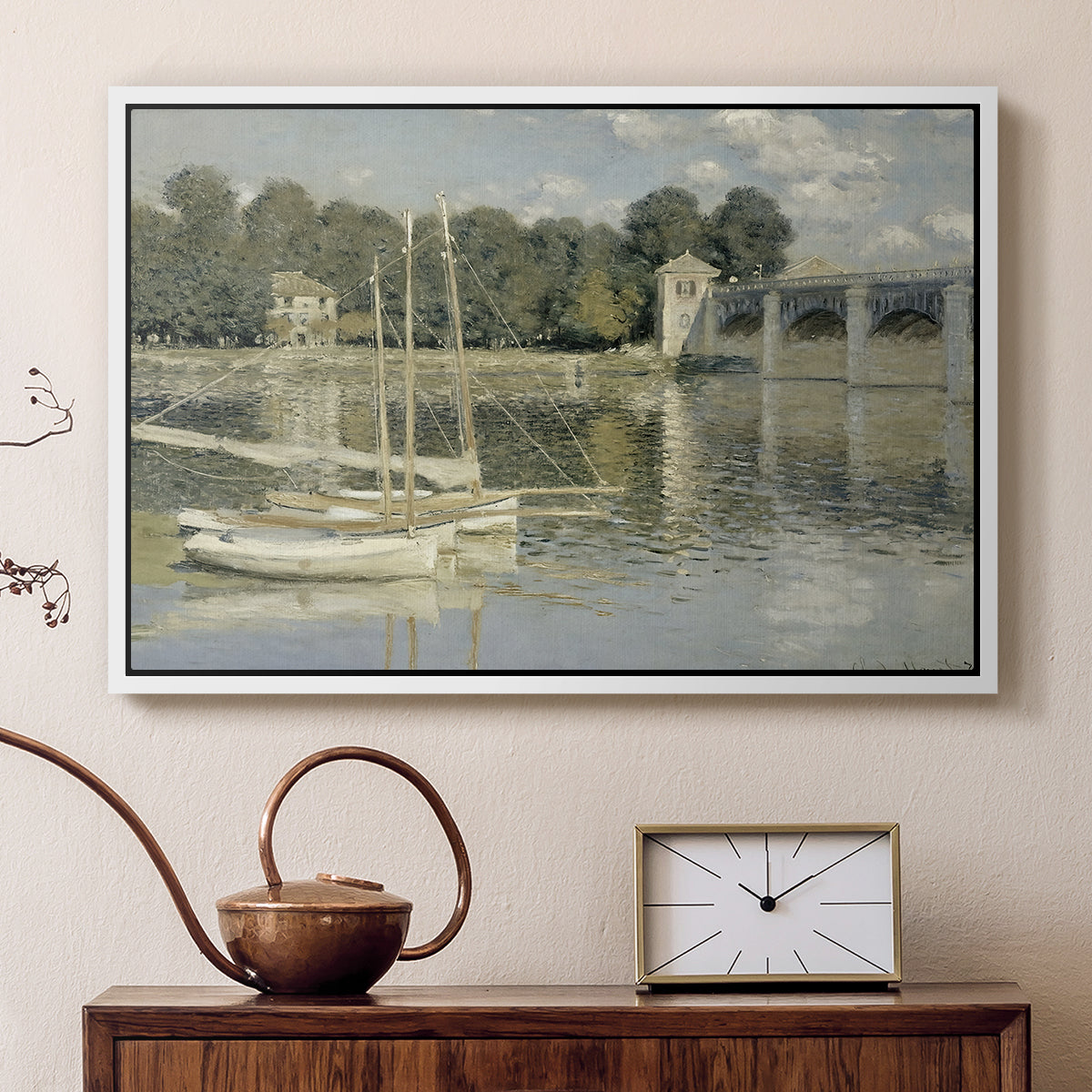 White floater framed canvas featuring a bright landscape featuring bridge and sailboats on calm water, displayed above a cabinet in a soft-toned living room.
