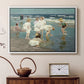 White floater framed canvas featuring an impressionist coastal view of families enjoying seaside water, displayed above a cabinet in a soft-toned living room.
