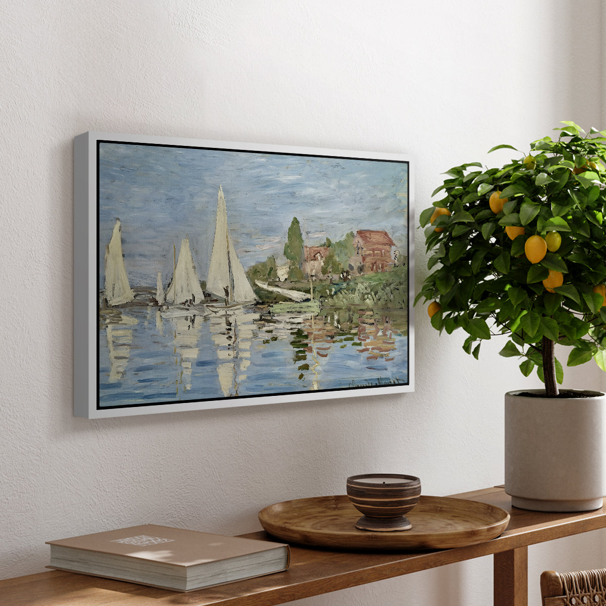 Regatta at Argenteuil, 1872 by Claude Monet, presented in a white floater framed canvas featuring colorful sailboats racing across river under bright sky, displayed above a hallway console table.
