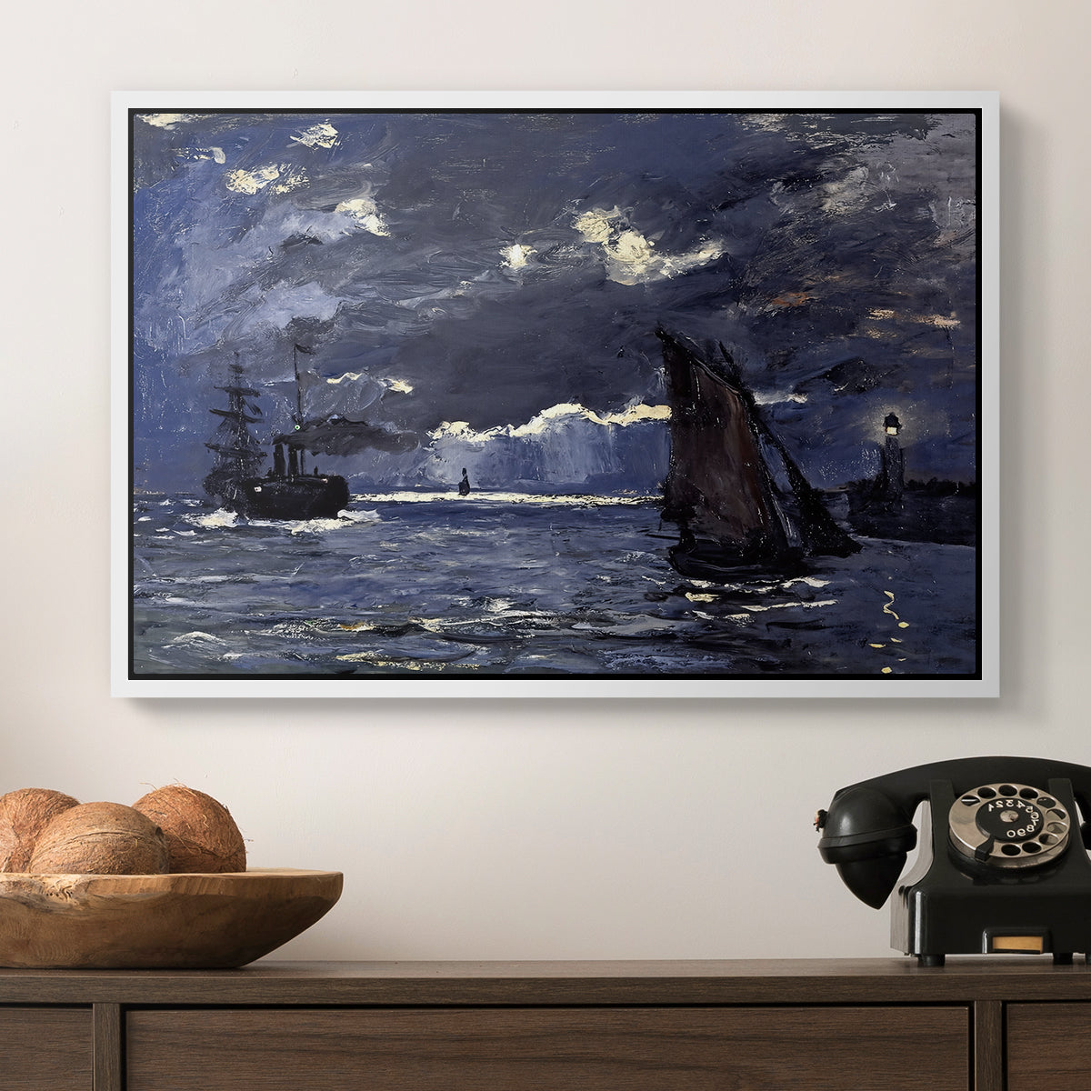A Seascape, Shipping by Moonlight, 1864 by Claude Monet in a white floater framed canvas displayed above a console table in a hallway, featuring an atmospheric maritime view with ships in moonlit darkness.
