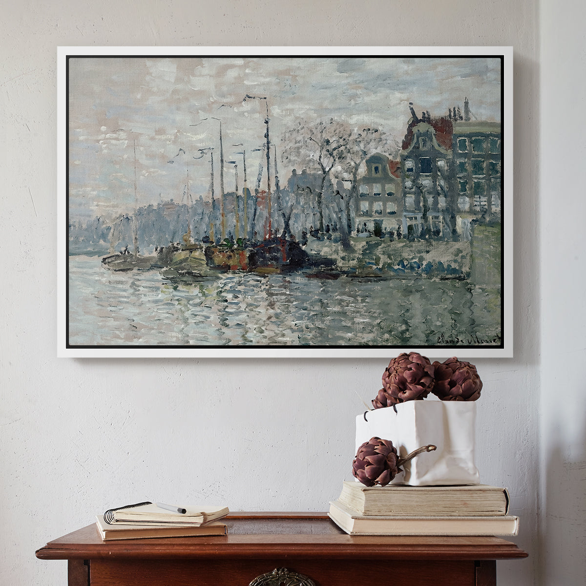White floater framed canvas featuring View of the Prins Hendrikkade and Kromme Waal in Amsterdam, 1874 by Claude Monet above an entryway table in a minimalist foyer.