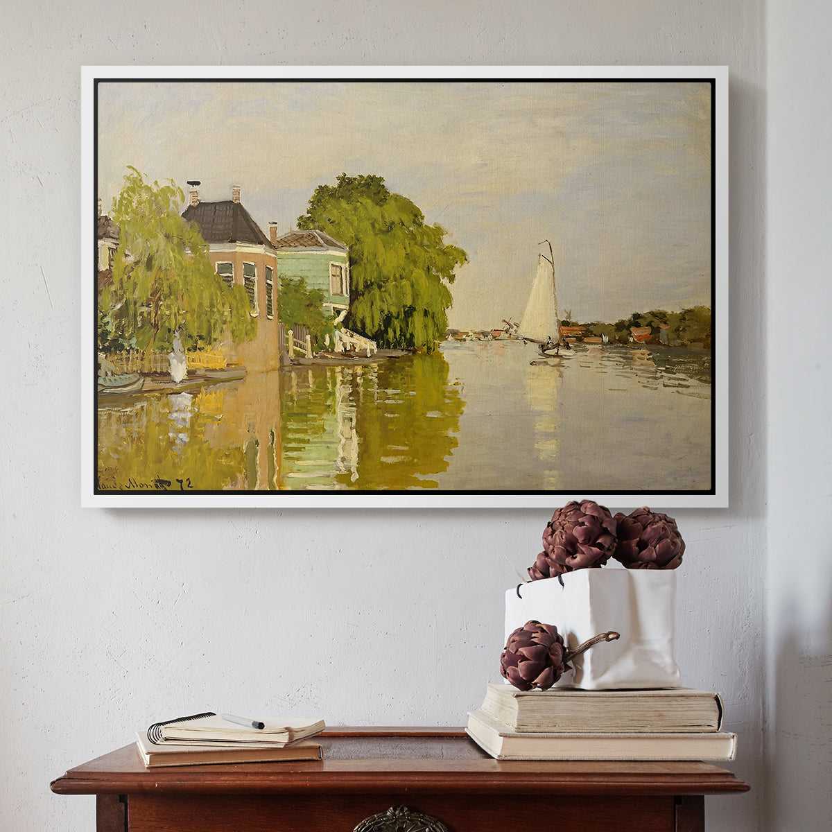 White floater framed canvas featuring Houses on the Achterzaan, 1871 by Claude Monet above an entryway table in a minimalist foyer.