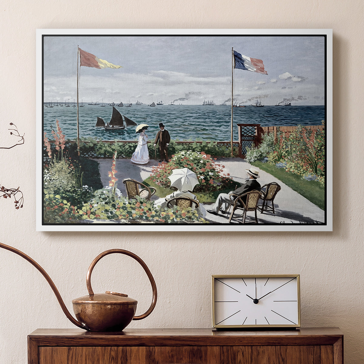 White floater framed canvas featuring a vibrant garden scene with colorful blooms and distant sea, displayed above a cabinet in a soft-toned living room.
