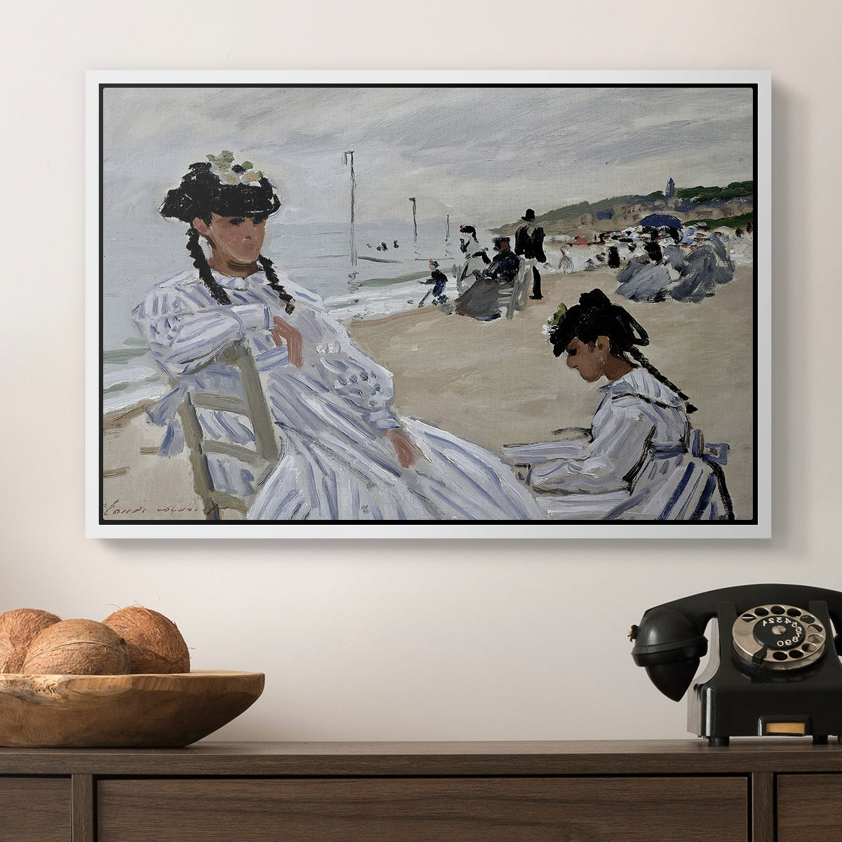 On the Beach at Trouville, 1870 by Claude Monet in a white floater framed canvas displayed above a console table in a hallway, featuring a coastal leisure scene with figures looking out to sea.