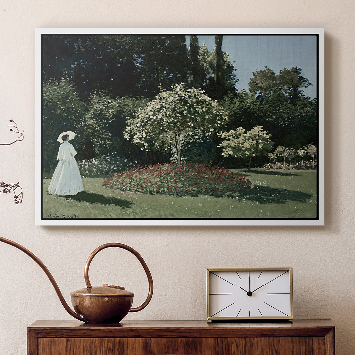 White floater framed canvas featuring an elegant woman posed outdoors among blooming plants, displayed above a cabinet in a soft-toned living room.