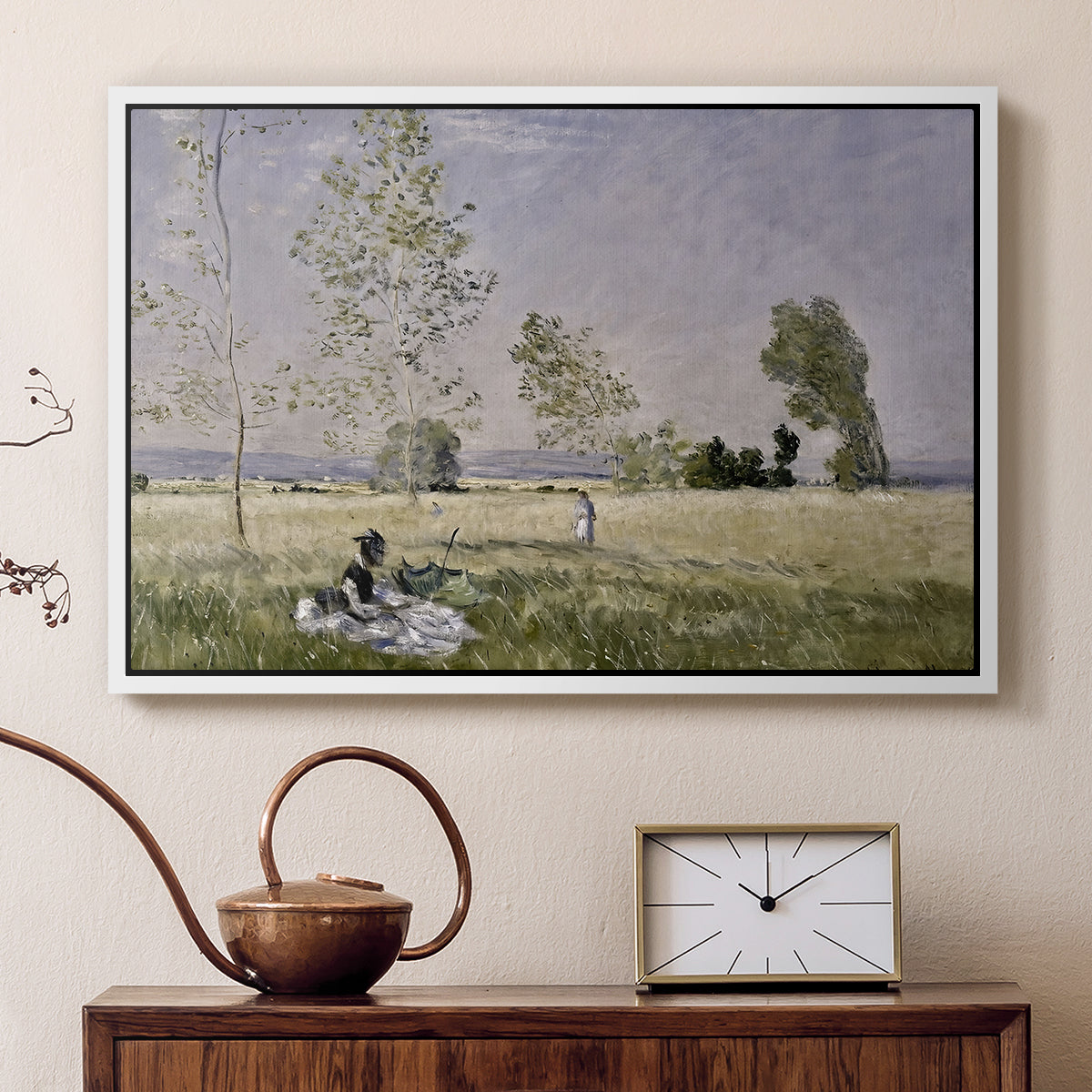 White floater framed canvas featuring a sunlit meadow with woman surrounded by greenery, displayed above a cabinet in a soft-toned living room.